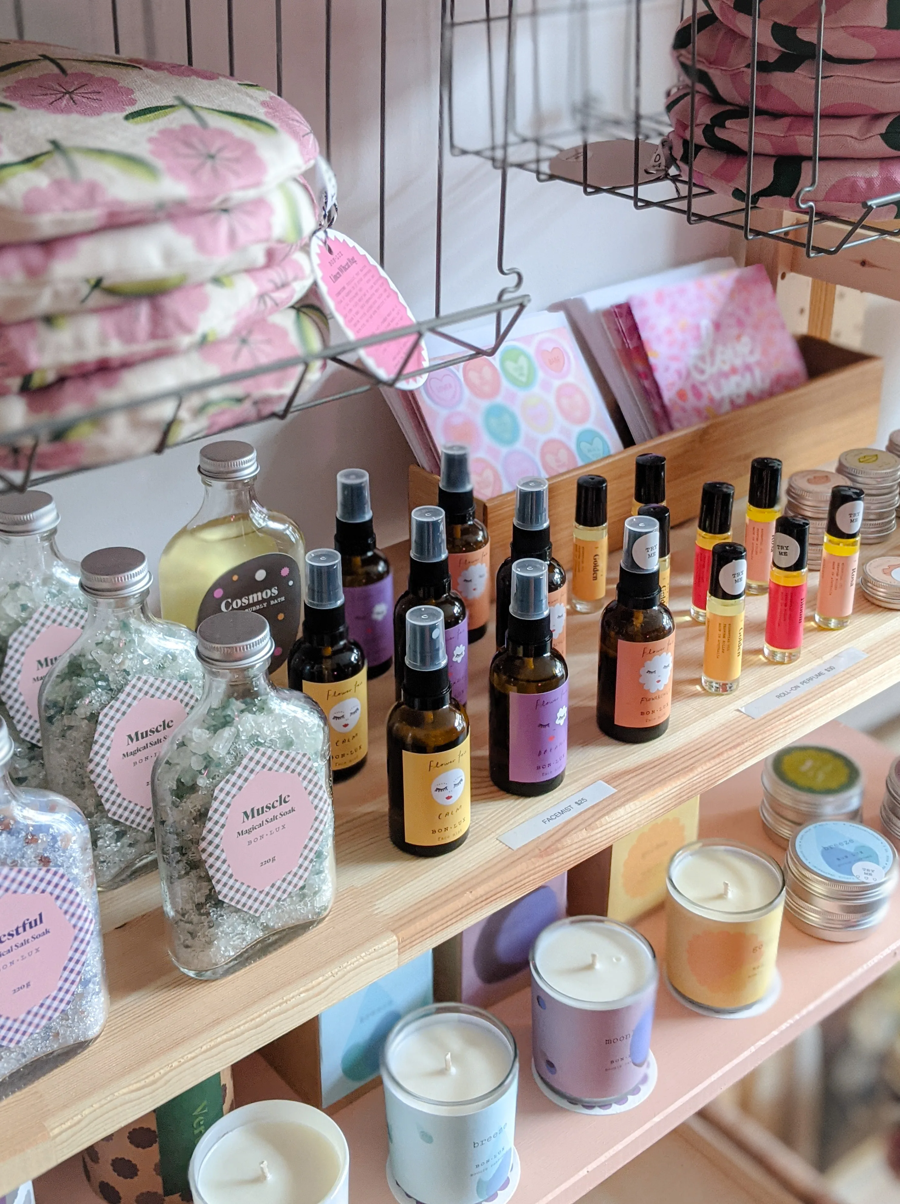 Candles and lifestyle products displayed on a retail shelf at Petal Pop Flowers