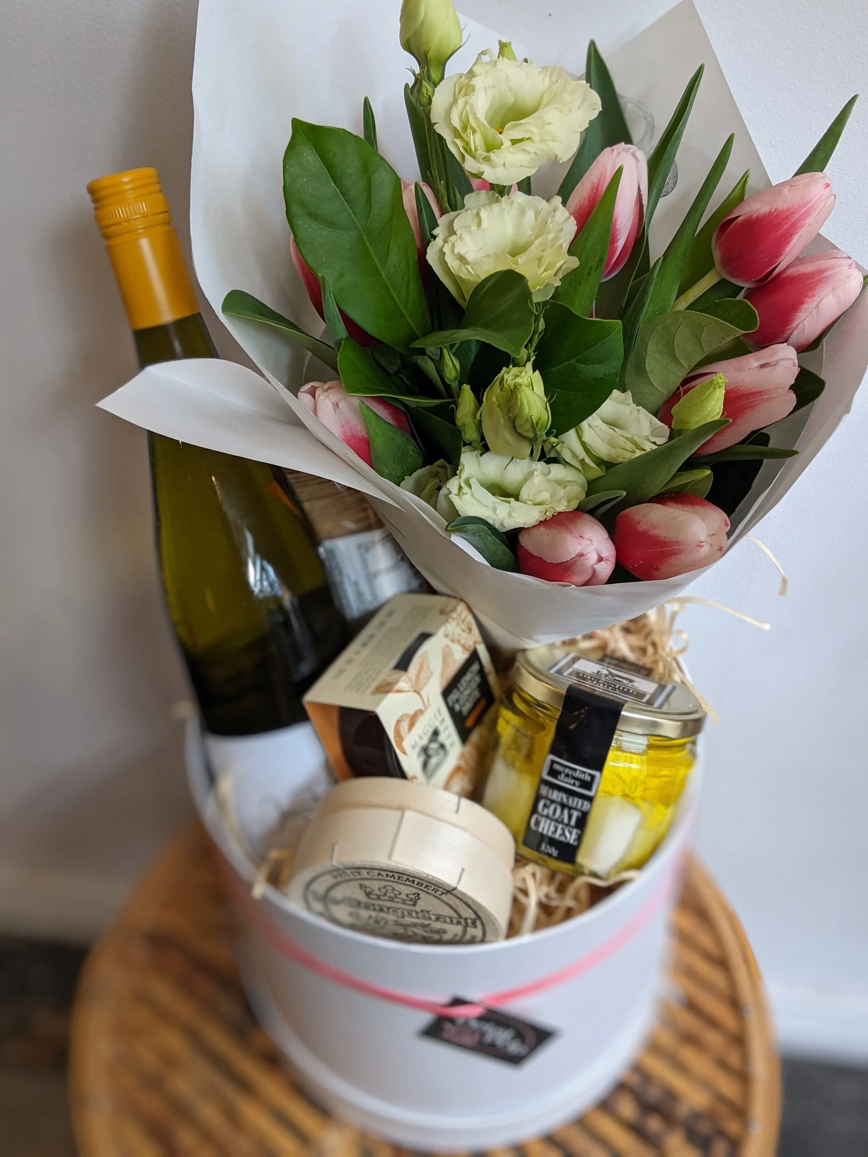 Gift hamper — tulip and lisianthus bouquet with wine and fine cheese in a round box